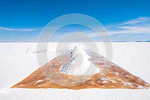 Man shovel sault banks in Salar de Uyuni