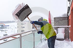 Man shoveling the show on the terrace