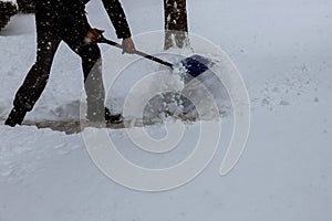 Man shoveling snow from the sidewalk in front of his house after a heavy snowfall Man Removing Snow with a Shovel