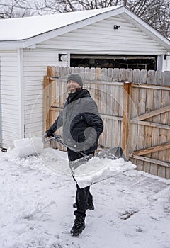 Man is shoveling snow from your sidewalk and driveway after a recent snow storm