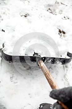 Man shovelling snow with a snow pusher or shovel, clear the snow