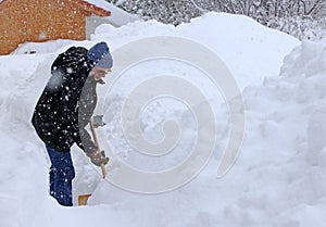 A man shovels a staircase free in heavy snowfall