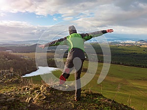 Man show airplane fly used arms as wings on rocky peak photo