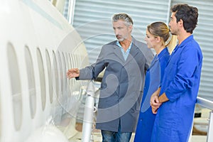 Man showing aircraft fuselage to students