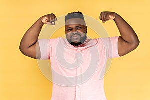 Man showing biceps raising strong arms, proud of muscular build, leadership.