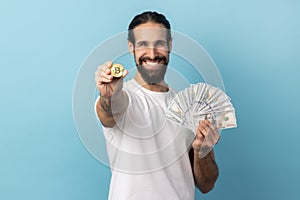 Man showing bitcoin and big fan of dollars banknotes, e-commerce, crypto currency.