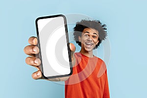 Man showing a blank phone screen on blue background