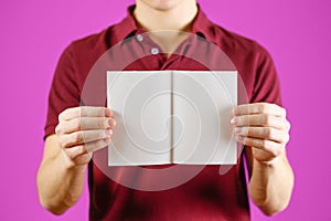 Man showing blank white flyer brochure booklet. Leaflet presentation