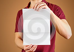 Man showing blank white flyer brochure booklet. Leaflet presentation. Pamphlet hold hands. Man show clear offset paper. Sheet
