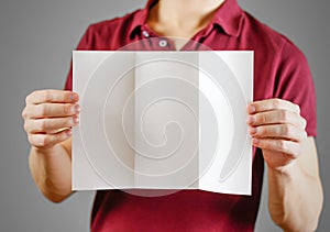 Man showing blank white flyer brochure booklet. Leaflet presentation. Pamphlet hold hands. Man show clear offset paper. Sheet