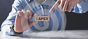Man showing Capex word on the wooden block