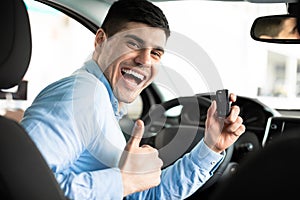 Man Showing Car Key And Thumb Up Sitting In Auto