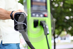 Man showing charging cord for eco cars