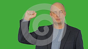 Man showing clenched fist up on right hand on green chroma key background. Alpha channel, keyed green screen.