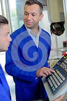 Man showing controls to younger man