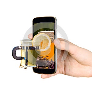 Man is showing cup with tea through mobile phone