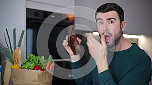 Man showing empty wallet after doing grocery shopping