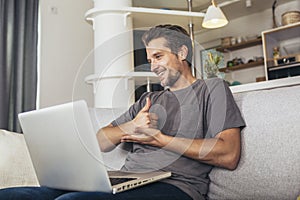 Man showing gesture in sign language using laptop, make video call
