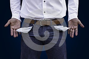 Man showing his empty pockets on wall background