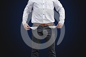 Man showing his empty pockets on wall background