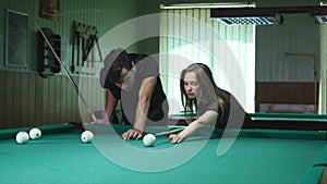 Man Showing His Girl Where To Hit The Ball - Young Woman Receiving Advice On Shooting Pool Ball While Playing Billiards