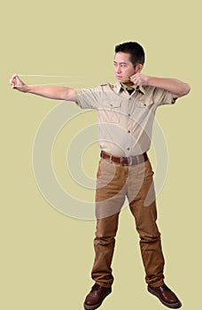 A man showing how to stretch rubber band of slingshot