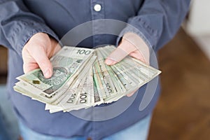 A man showing hundreds of Zloty - Polish money.