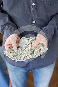 A man showing hundreds of Zloty - Polish money.