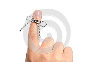 Man showing index finger with tied striped bow as reminder on white background, closeup