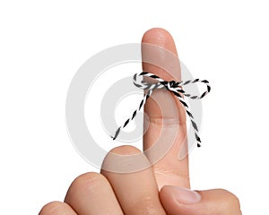 Man showing index finger with tied striped bow as reminder on white background, closeup