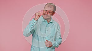 Man showing a little bit gesture with sceptic smile, showing minimum sign, measuring small size