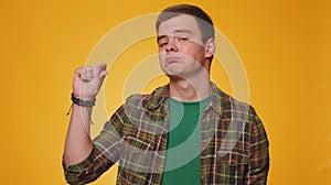 Man showing a little bit gesture with sceptic smile, showing minimum sign, measuring small size