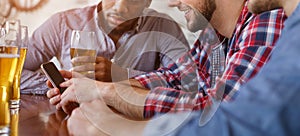 Man Showing New App On Smartphone, Resting In Bar With Friends