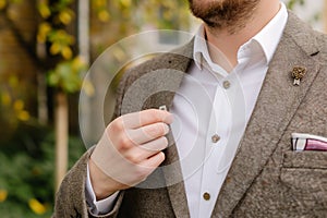 man showing off a bohostyle lapel pin on a blazer photo