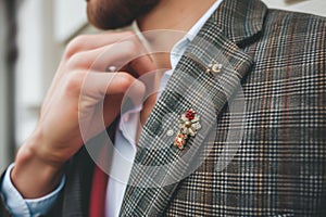 man showing off a bohostyle lapel pin on a blazer photo