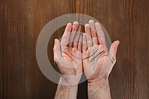 Man showing palms with drawn lines on background, top view. Chiromancy and foretelling photo