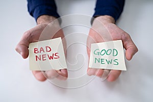 Man Showing Paper With Good And Bad News