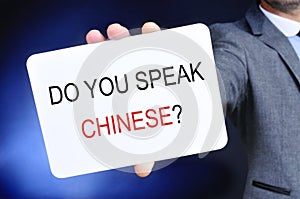 Man showing a signboard with the question do you speak chinese?