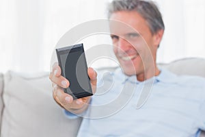 Man showing smartphone to camera