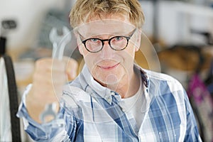 man showing spanner at camera