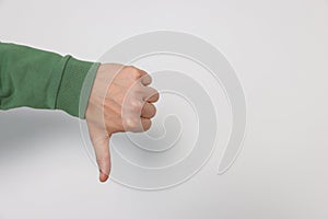 Man showing thumb down on white background, closeup. Space for text