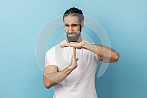 Man showing time out gesture, looking with strict expression, deadline.