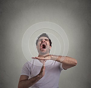 Man showing time out hand gesture, frustrated screaming to stop