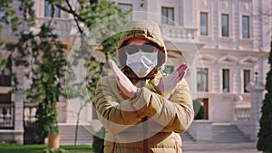 A man showing to stop the Coronavirus it s need to wear a protective mask while he are in the middle of the empty street