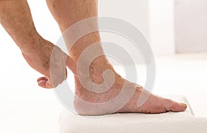 Man showing Varicose veins closeup, foot on modular bath step