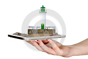 Man is showing white lighthouse with green details through mobile phone