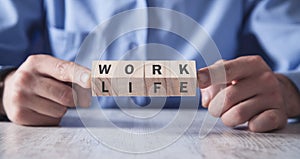 Man showing wooden cubes. Work Life Balance