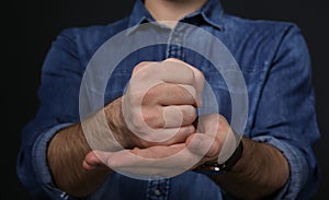 Man showing word CRUCIFY in sign language on black background