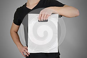 Man shows blank plastic bag mock up isolated. Empty white polyethylene package mockup. Consumer pack ready for logo design or ide