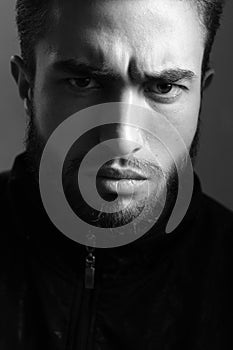 A man shows different human emotions. Close-up black and white portrait of a young handsome Caucasian male in studio.